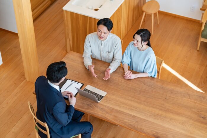 不動産会社と打ち合わせをする夫婦