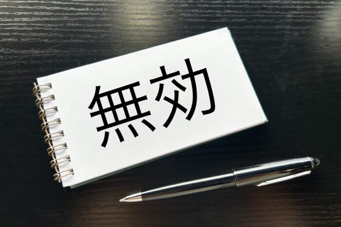 「無効」と書かれたメモ帳とボールペン
